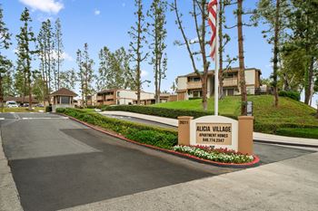 the sign for acacia village at the entrance to the street with apartments in the